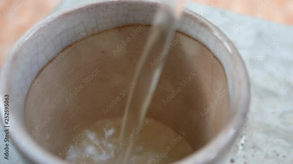 Video of pouring tea from the tea pot in Japanese/Chinese style into the small tea glass Video of pouring tea from the tea pot in Japanese/Chinese style into the small tea glass