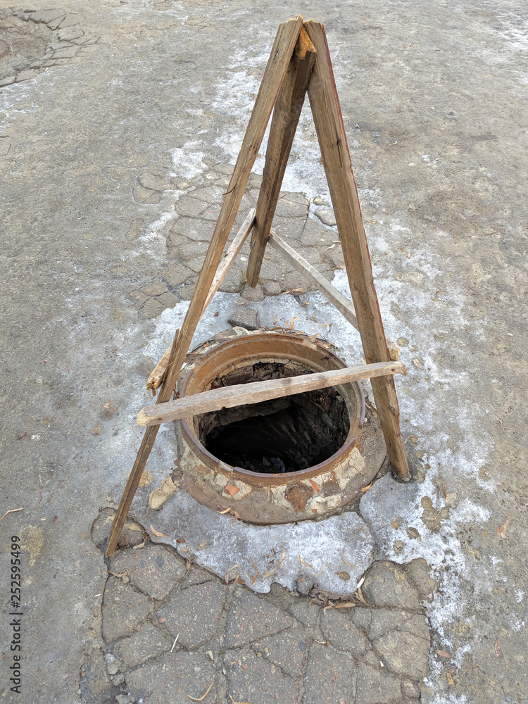 Dangerous opened manhole hole cover, danger for people who walking on the street in the city