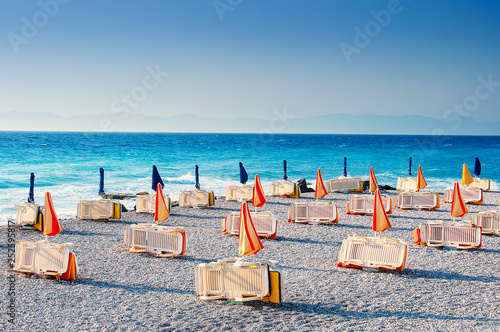Sunbeds with umbrellas at the Rhodes city beach in Rhodes island in Greece