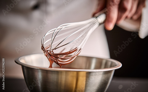 Quadro su tela Chef preparing melted chocolate in a mixing bowl