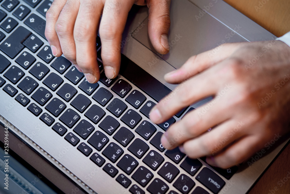 Male hands typing on a laptop keyboard - Business concept Male hands typing on a laptop keyboard - Business concept