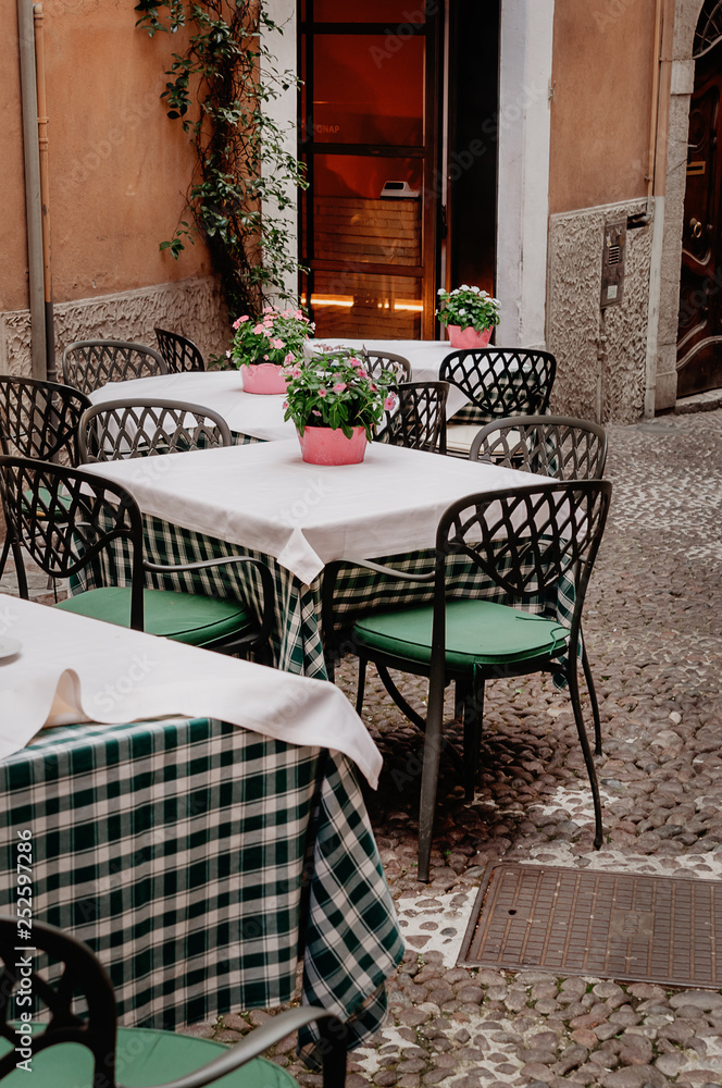 Fototapeta premium empty tables and chairs in the street cafe. Social distance and pandemic isolation concept