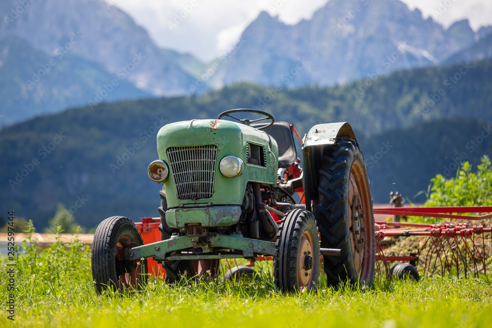 Fototapeta premium Old tractor in the Alpine meadows