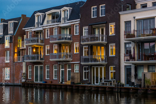 beautiful and luxurious terraced houses at the canal, Dutch city architecture by night, Alphen aan den Rijn, The Netherlands photo