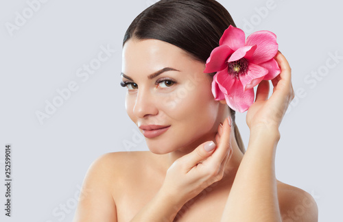 Portrait of a woman with beautiful make-up holds a Magnolia flower in his hands. Professional makeup and skin care.