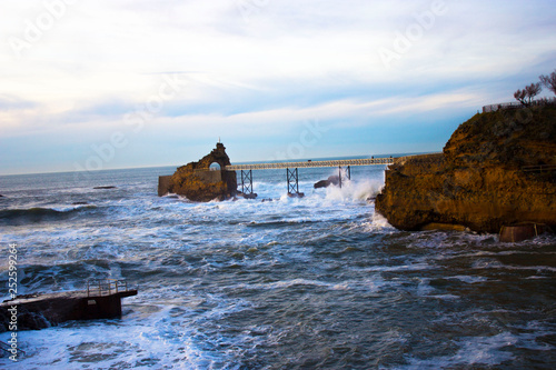 The bridge between the rocks in the Bay of Biscay and the waves crashing against the shore.