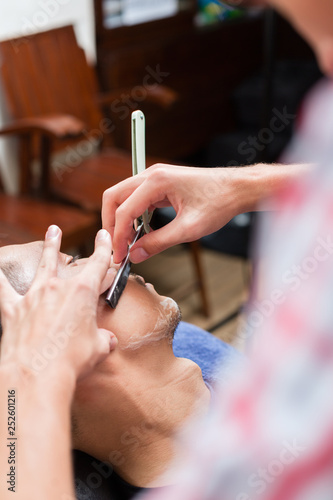 Professional barber shaving with razor