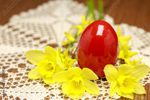 With a red easter egg and daffodils.