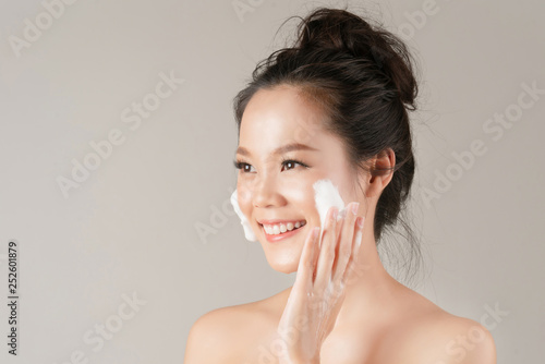 Asian women are going to use a facial foam to wash cosmetics off the face photo