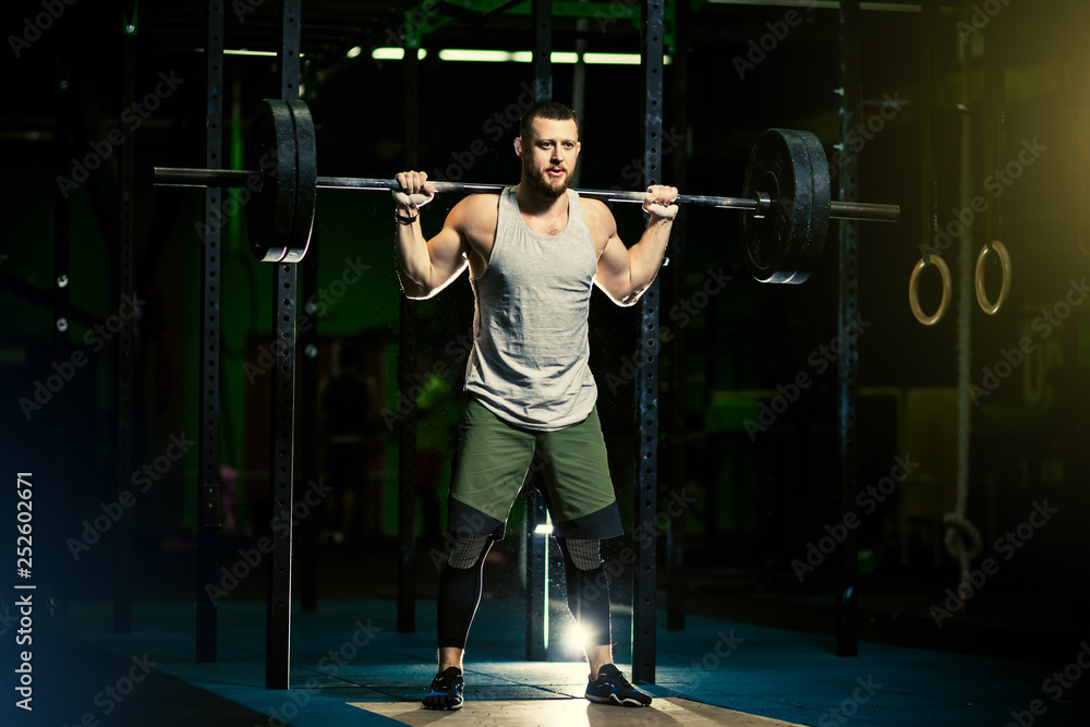 Man with heavyweight barbell in the dark gym. Man with heavyweight barbell in the dark gym.