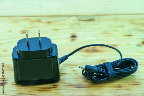 Electrical charging devices for mobile telephone on a wooden background. photo