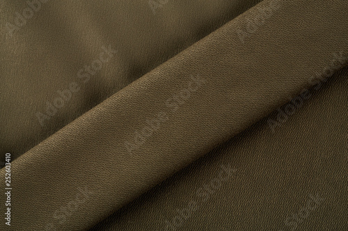 Green cotton textile - close up of fabric texture. Cotton Fabric Texture. Top View of Cloth Textile Surface. Green Clothing Background. Text Space. Abstract background and texture for designers.