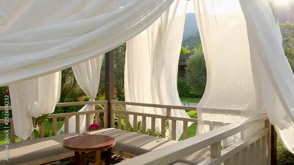 Outdoor wooden gazebo with white curtains. Outdoor wooden gazebo with white curtains.