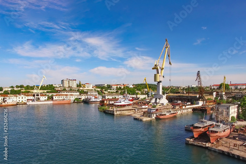 Aerial view of the cityscape overlooking the port with ships and cranes.