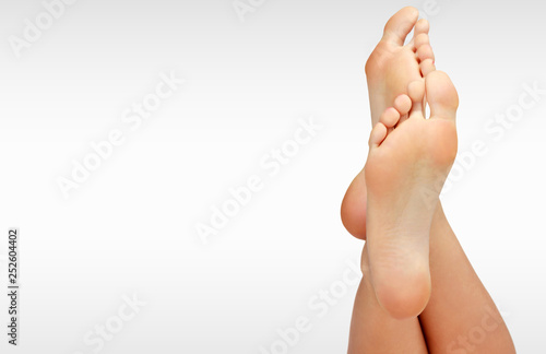 Beautiful woman's bare feet against a grey background with copyspace photo