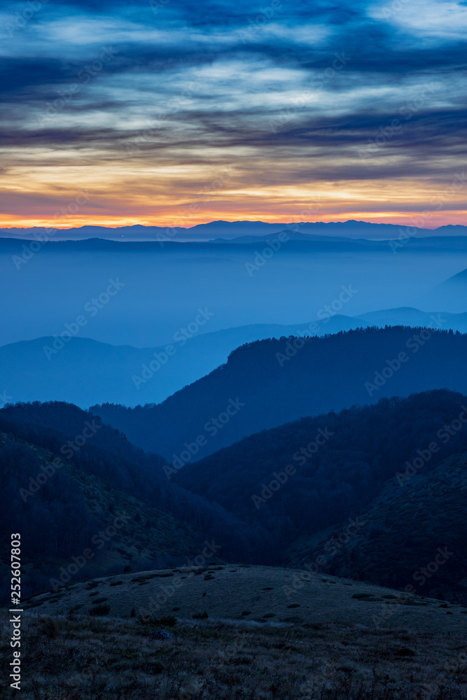 Layers of Mountain Ridges with fog at sunset