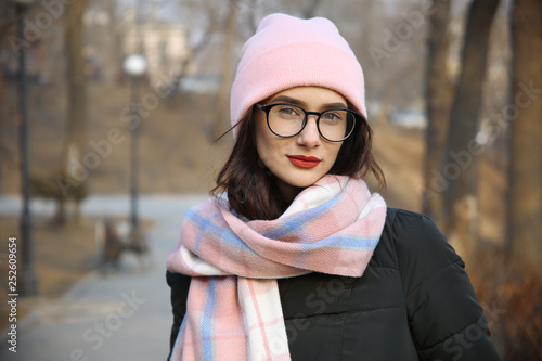 portrait of a cute girl with glasses and a hat on the street