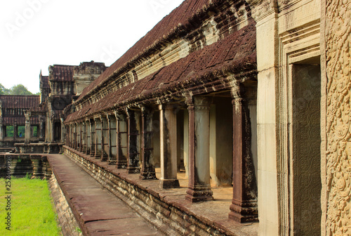 Exterior a open stone gallery or corridor of Angkor Wat temple at Siem Reap, Cambodia. Largest religious monument in the world and popular tourist attraction. Object a UNESCO World Heritage Site.