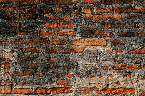 Grunge dirty old brick stone wall exterior texture on ancient Old city wall architecture in Lopburi, Thailand
