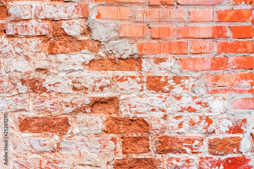 Old vintage red brick wall with sprinkled white plaster texture background. Horizontal