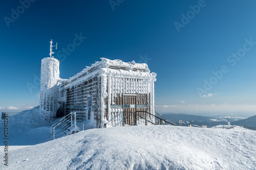 Frozen summit hut in sunny winter, Snezka peak, Giant mountains, Czech republic photo