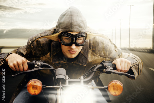 Bild auf Leinwand Junger Motorradfahrer im Retro Look fährt auf einer Straße