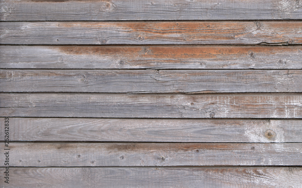 The unique texture of time-aged wooden boards with yellowish stains on an uneven surface The unique texture of time-aged wooden boards with yellowish stains on an uneven surface