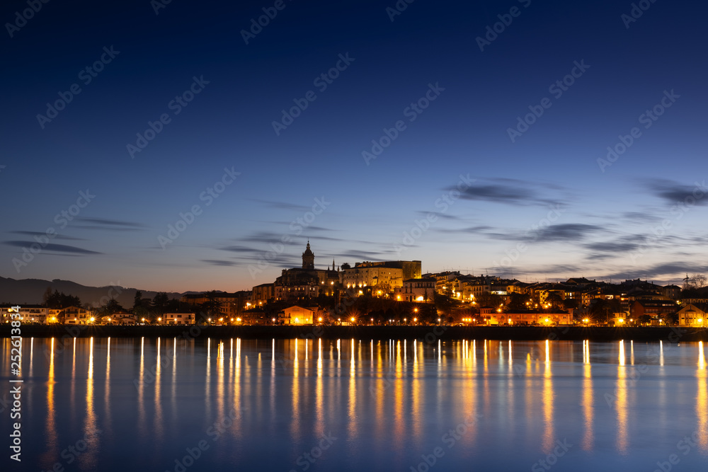 The lights of the city of Hondarribia are reflected in the sea water at night, Euskadi