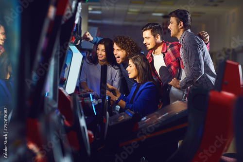 Foto A group of friends playing arcade machine.