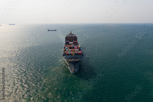 Aerial view. Container ship in pier with crane bridge carries out export and import business in the open sea. Logistics and transportation