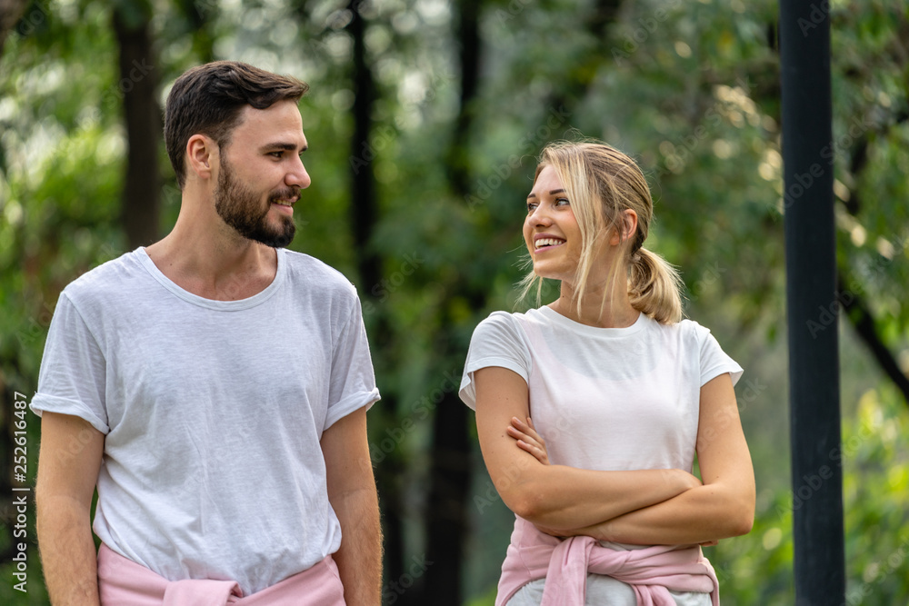 Man and Woman looking each other smiling and walking together in the public park