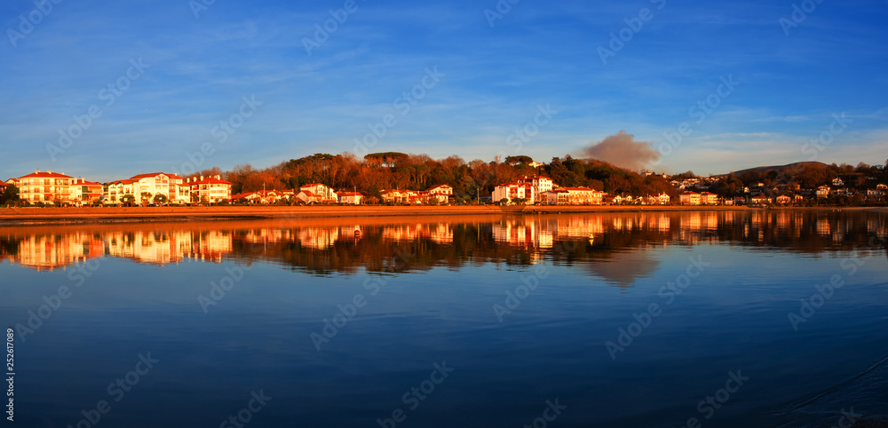 houses reflected in the water of the beach at sunset, Hendaia, France