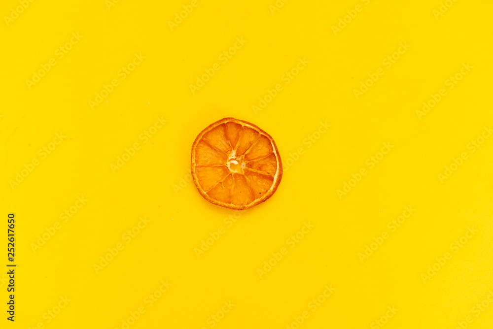 slice of tangerine on yellow background slice of tangerine on yellow background