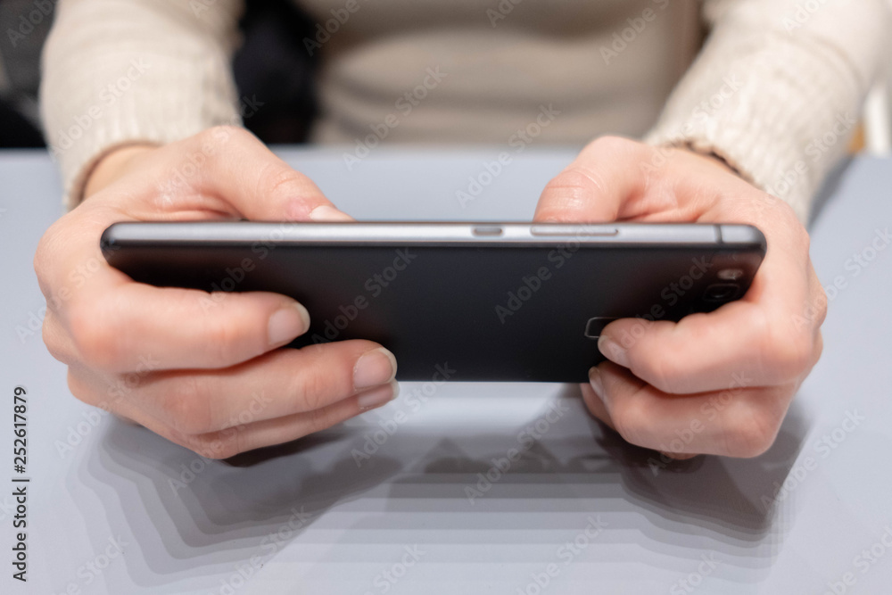 Young female hans with black smarphone watching screen. Young female hans with black smarphone watching screen.