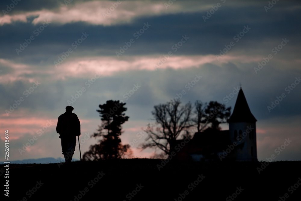 Fototapeta premium Old man on its way to church.