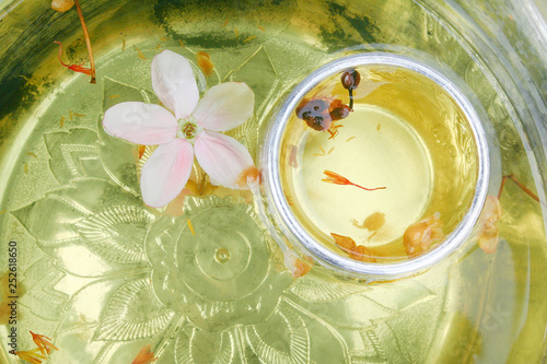 Acacia concinna or som poi in silver bowl with water and pink flower top view  use in Songkran Festival  , sprinkle water onto a Buddha image photo