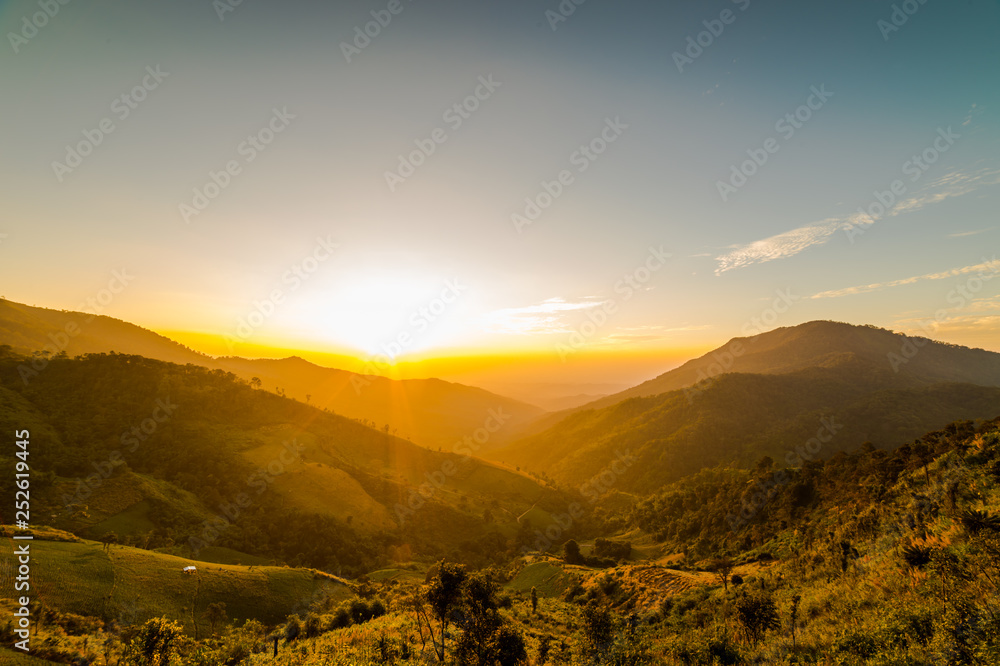 Obraz premium The sun sets behind the mountains, the scenic spot.