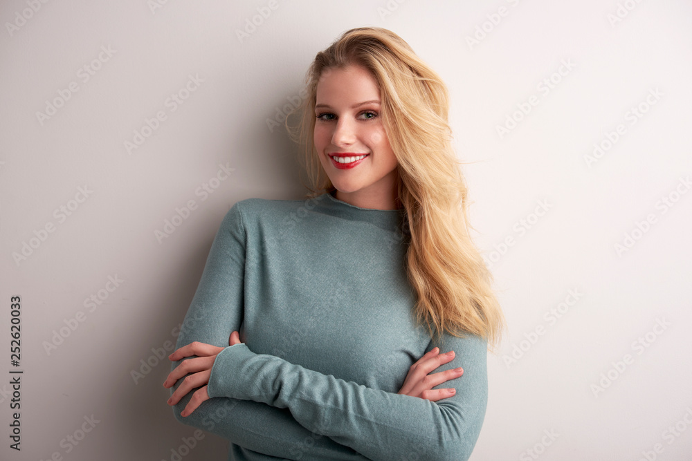 Studio portrait of beautiful young woman standing at light grey background Studio portrait of beautiful young woman standing at light grey background