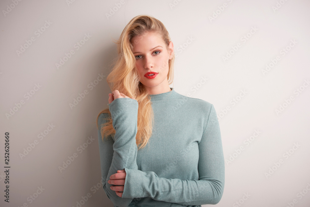 Studio portrait of beautiful young woman standing at light grey background Studio portrait of beautiful young woman standing at light grey background