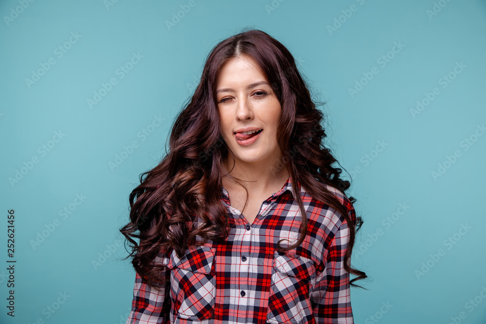 Pretty woman winking isolated over the blue background Pretty woman winking isolated over the blue background