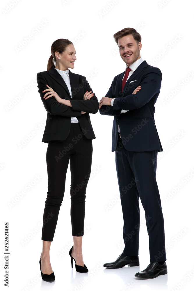 couple in business suits standing together with arms crossed