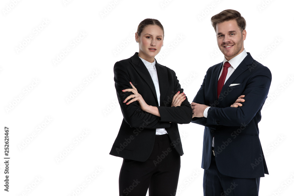 couple in business suits standing together with arms crossed couple in business suits standing together with arms crossed