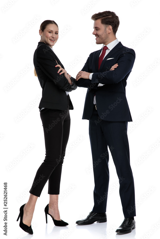 couple in business suits standing together with arms crossed couple in business suits standing together with arms crossed