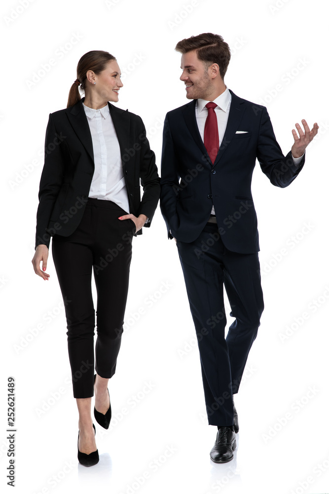 couple in business suits walking and talking with hand gestures couple in business suits walking and talking with hand gestures