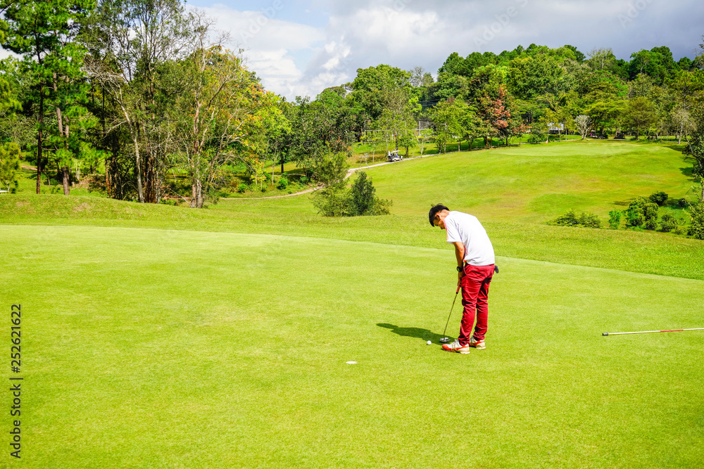 Golfer playing golf in beautiful golf course in the evening golf course with sunshine in thailand Golfer playing golf in beautiful golf course in the evening golf course with sunshine in thailand
