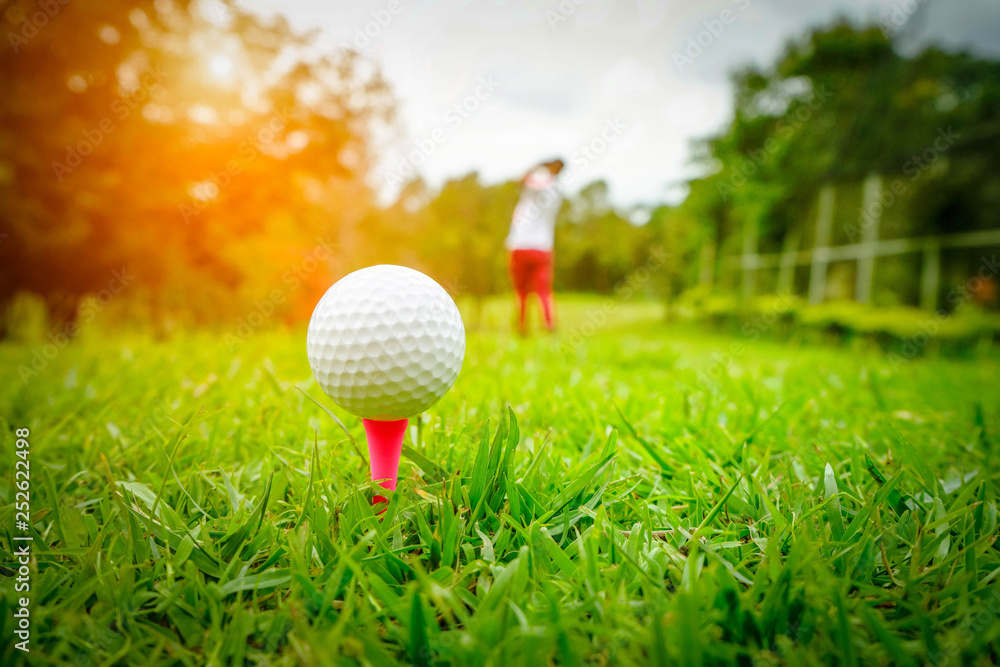 Golf ball on tee in beautiful golf course at sunset background. Golf ball on green in golf course at Thailand Golf ball on tee in beautiful golf course at sunset background. Golf ball on green in golf course at Thailand