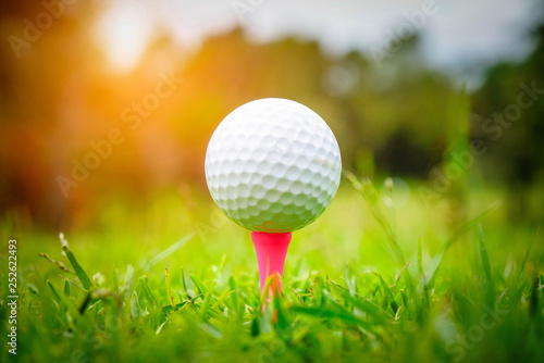 Golf ball on tee in beautiful golf course at sunset background. Golf ball on green in golf course at Thailand