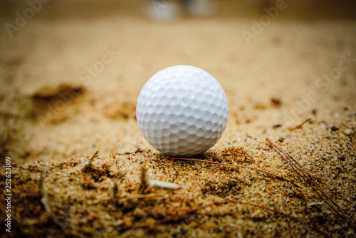 Golf ball on sand bunker in beautiful golf course at sunset background. Golf ball on green in golf course at Thailand