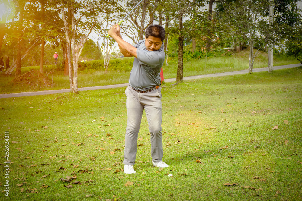 Golfer playing golf in beautiful golf course in the evening golf course with sunshine in thailand Golfer playing golf in beautiful golf course in the evening golf course with sunshine in thailand