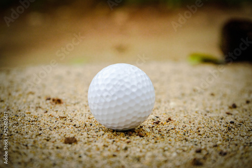 Golf ball on sand bunker in beautiful golf course at sunset background. Golf ball on green in golf course at Thailand